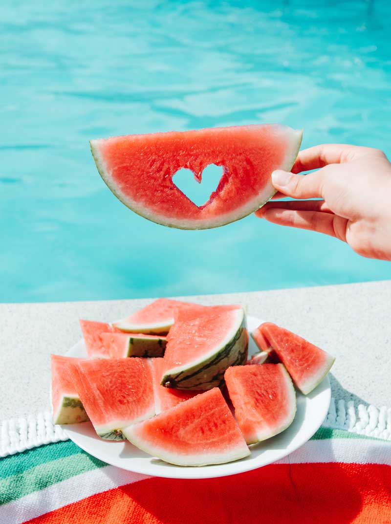 watermelon slice by a pool with love heart shape cut out